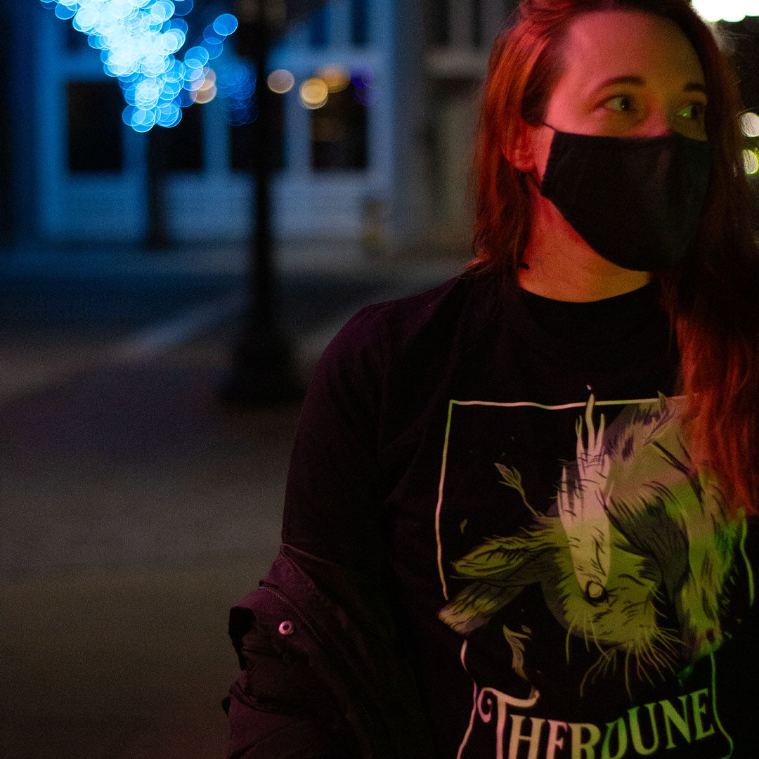 Black shirt with graphic of a falling rabbit, smokey tears coming out from the rabbit's eye. "Therdune" logo framed below. Worn by model, in an urban setting.