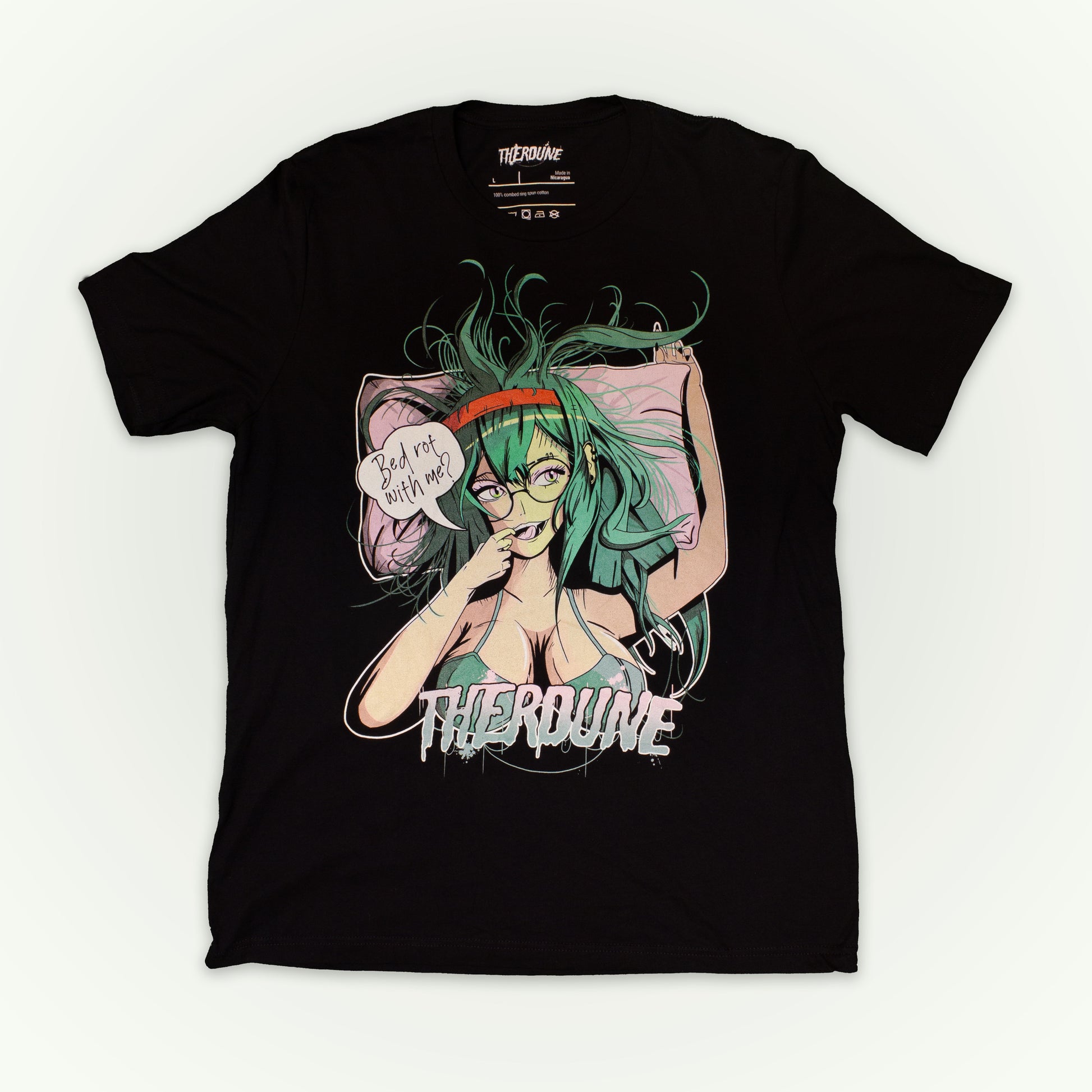 Black shirt with anime style woman, teal hair and bra, with speech bubble saying "Bed Rot With Me?". Flat lay on white background.