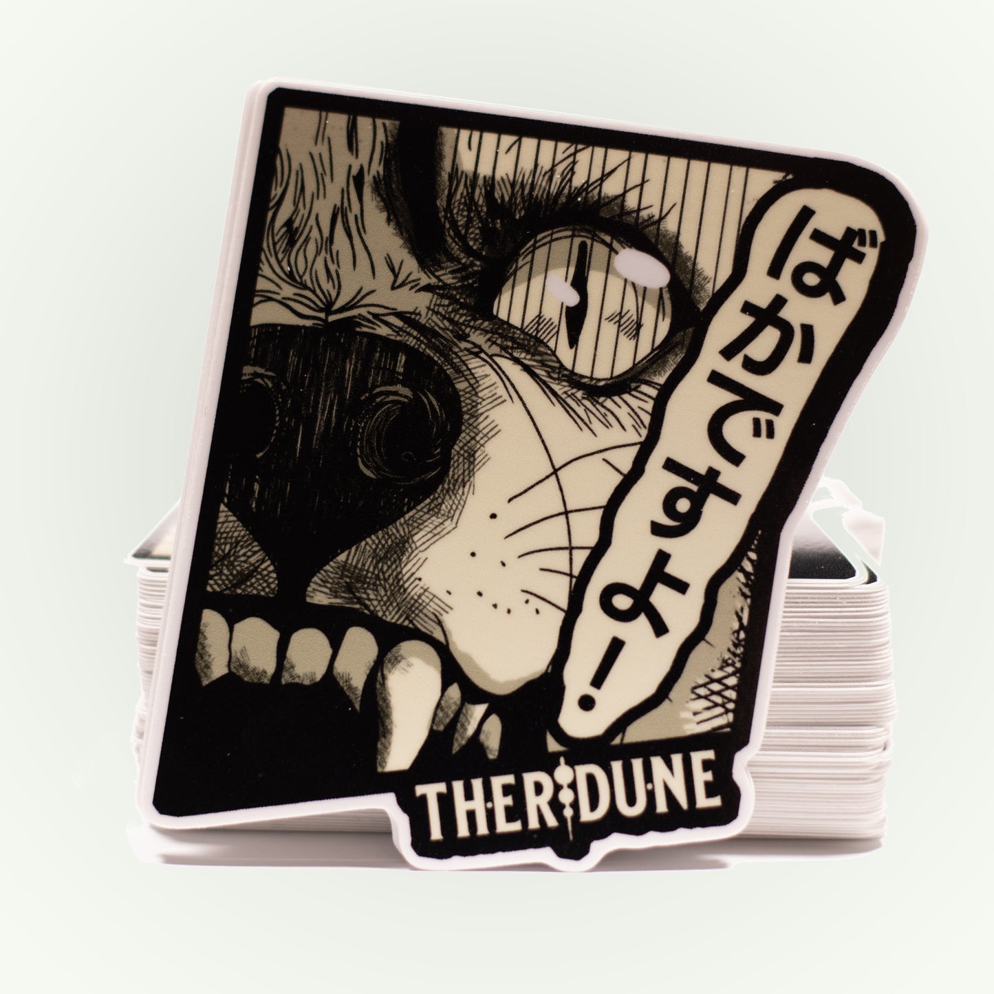 black and white manga style wolf, japanese characters that say "bakadesuyo" and an english Therdune logo.
