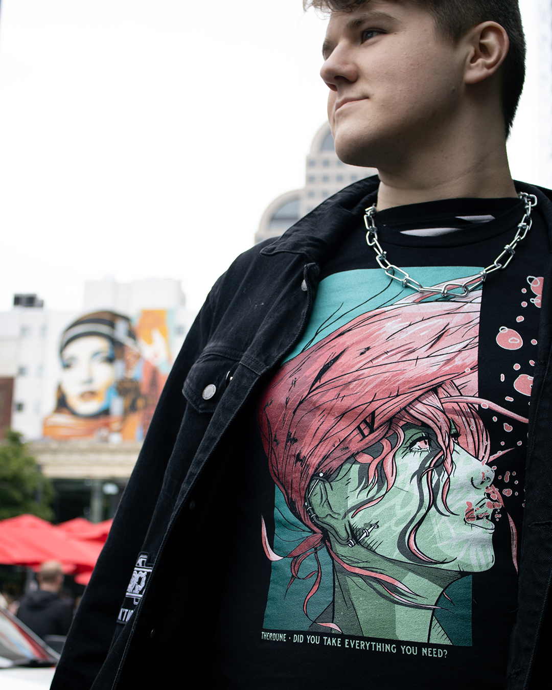 Black shirt with a woman underwater with pink hair. Text that says "Did you take everything you need? - Therdune". worn by a model in an urban setting.