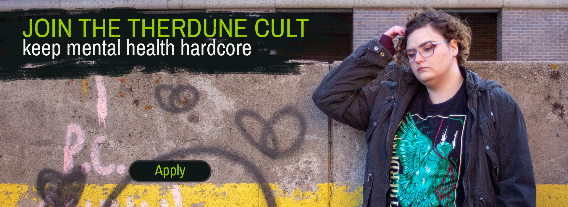 Person standing against a graffiti-covered wall with promotional text stating "Join the therdune cult, keep mental health hardcore"
