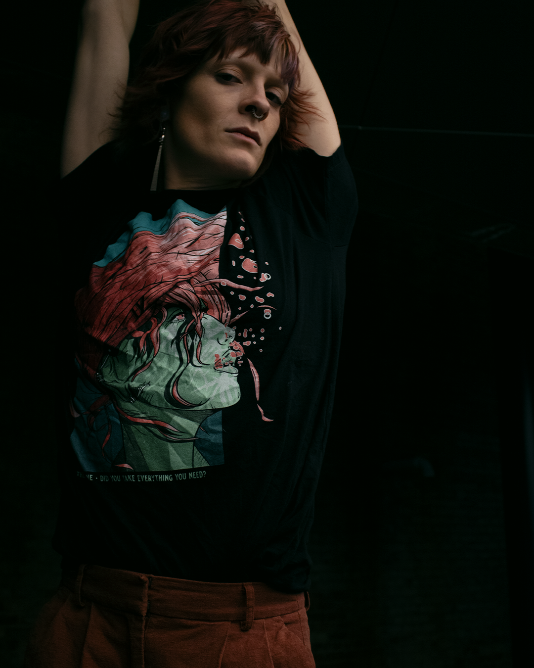 Black shirt with a woman underwater with pink hair. Text that says "Did you take everything you need? - Therdune". worn by a model with a black background.