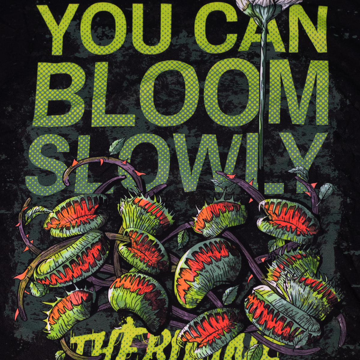 Black shirt with venus fly traps and one long, tall sprouting flower above. Text reads "you can bloom slowly" and a Therdune logo.