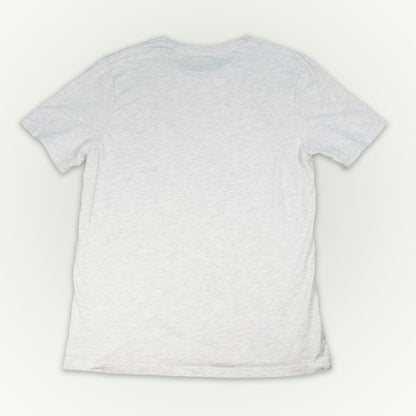 The back of a ash short-sleeve crewneck t-shirt laid flat against a light off-white background. 