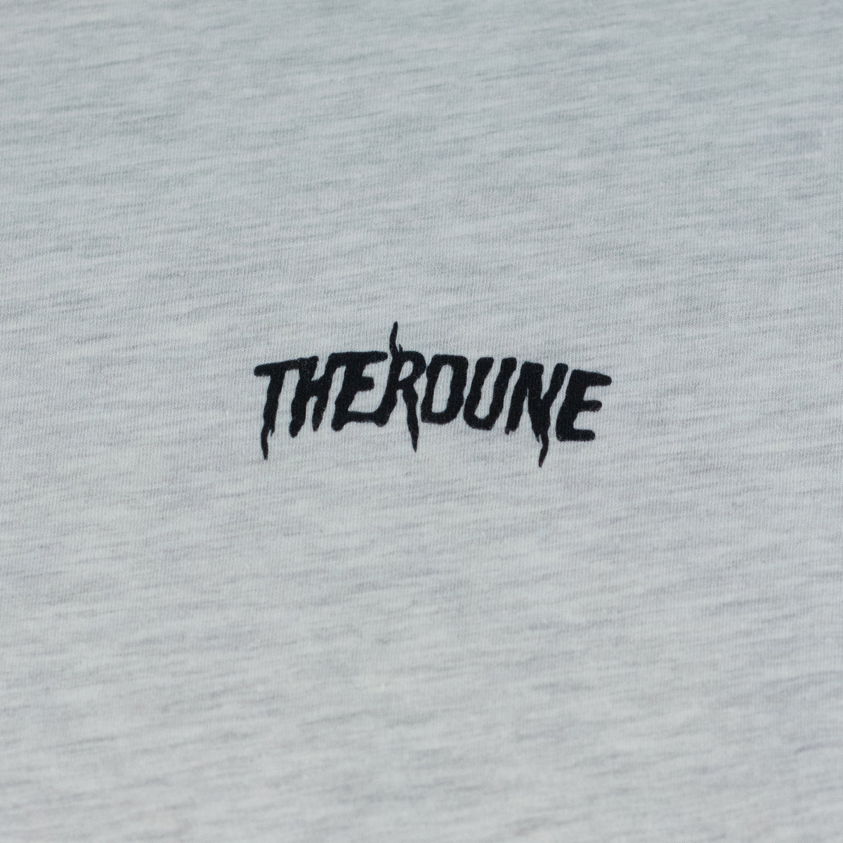 Close-up of an ash short-sleeve crewneck t-shirt laid flat. A black Therdune logo is printed on fabric.