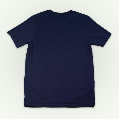 The back of a navy short-sleeve crewneck t-shirt laid flat against a light off-white background. 