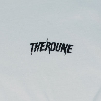 Close-up of a white short-sleeve crewneck t-shirt laid flat. A black Therdune logo is printed on fabric.