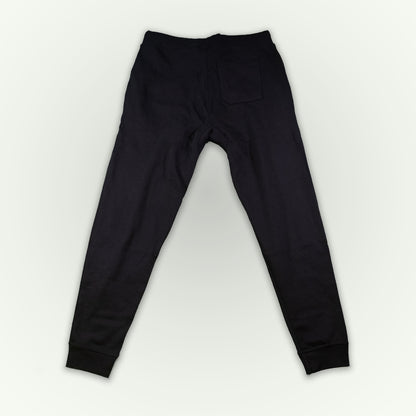 Black sweatpants shown from the back, featuring a single back pocket and ribbed cuffs, laid flat on a light white background.