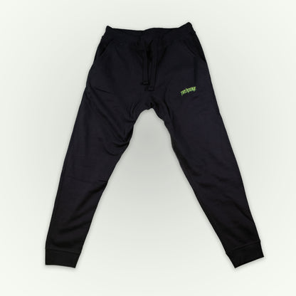Fitted black jogger sweatpants with a small lime green 'Therdune' logo on the upper left thigh, displayed flat against a light off-white background.