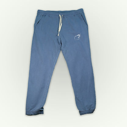 Blue jean colored fitted sweatpants with a small white 'Therdune Slug' logo embroidered on the upper left thigh, displayed flat against a light off-white background.
