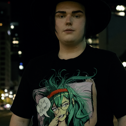 Black shirt with anime style woman, teal hair and bra, with speech bubble saying "Bed Rot With Me?", worn by model, in urban setting.